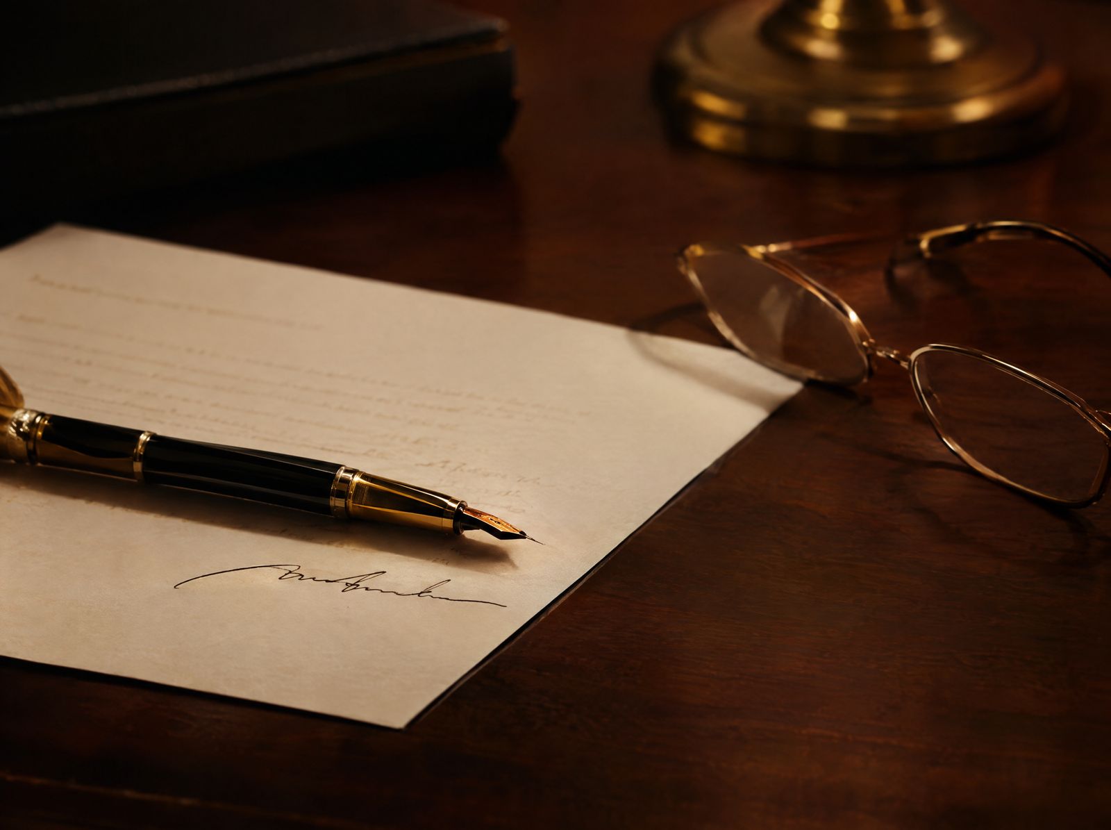 A pen and document on a walnut desk